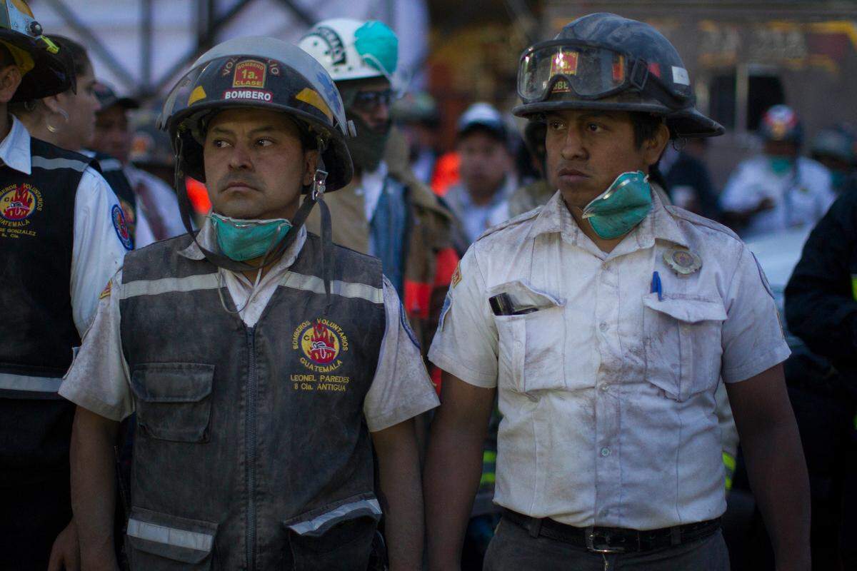 Firefighters regroup after working on the evacuation of residents near Volcan de Fuego, or Volcano of Fire, in Alotenango, Guatemala, Sunday, June 3, 2018. One of Central America's most active volcanoes erupted in fiery explosions of ash and molten rock Sunday, killing people and injuring many others while a towering cloud of smoke blanketed nearby villages in heavy ash.