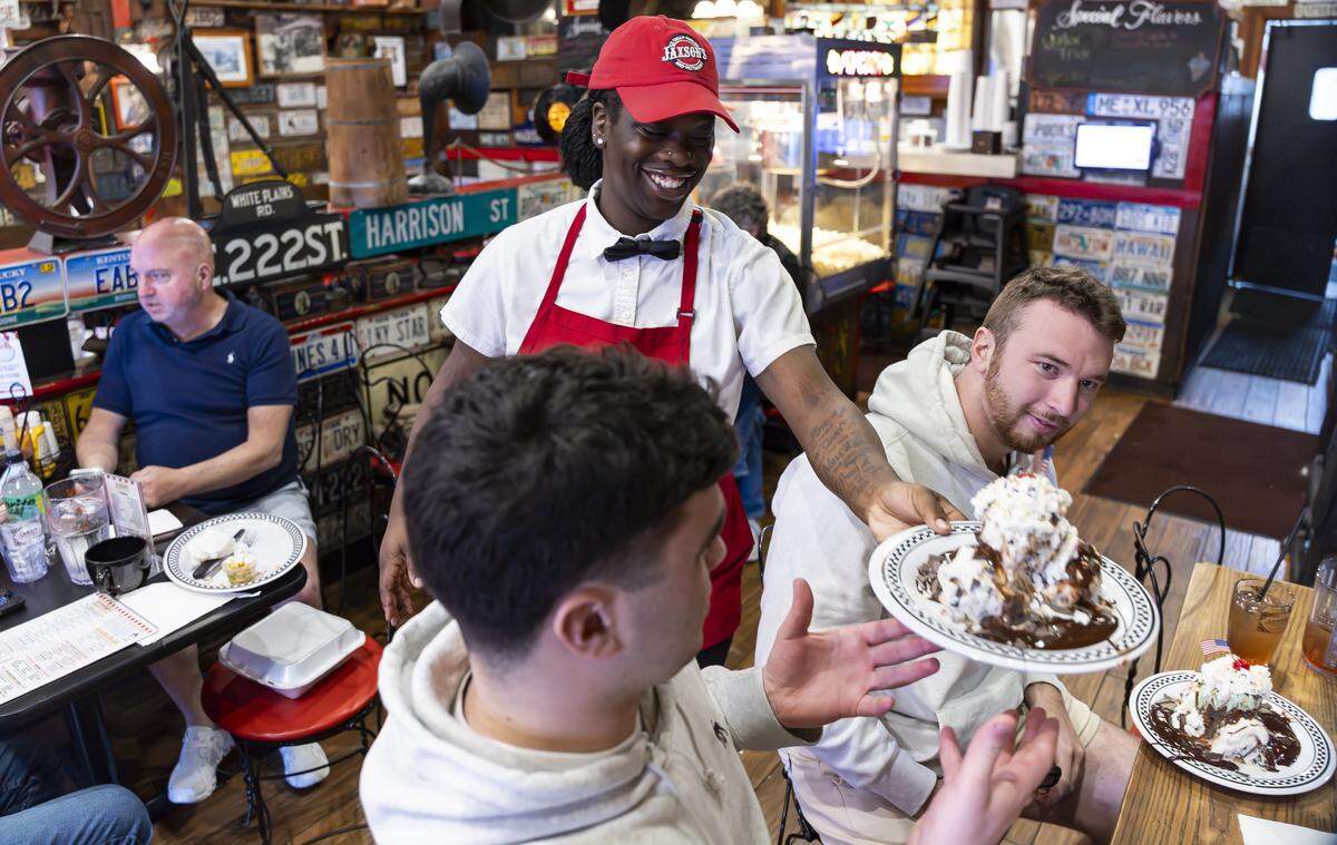 Jakaiya Coleman, a server at Jaxson's Ice Cream Parlor & Restaurant, serves customers ice cream on Thursday, Feb. 5, 2026, in Dania Beach, Fla. Jaxson's is celebrating its 70th anniversary this month.