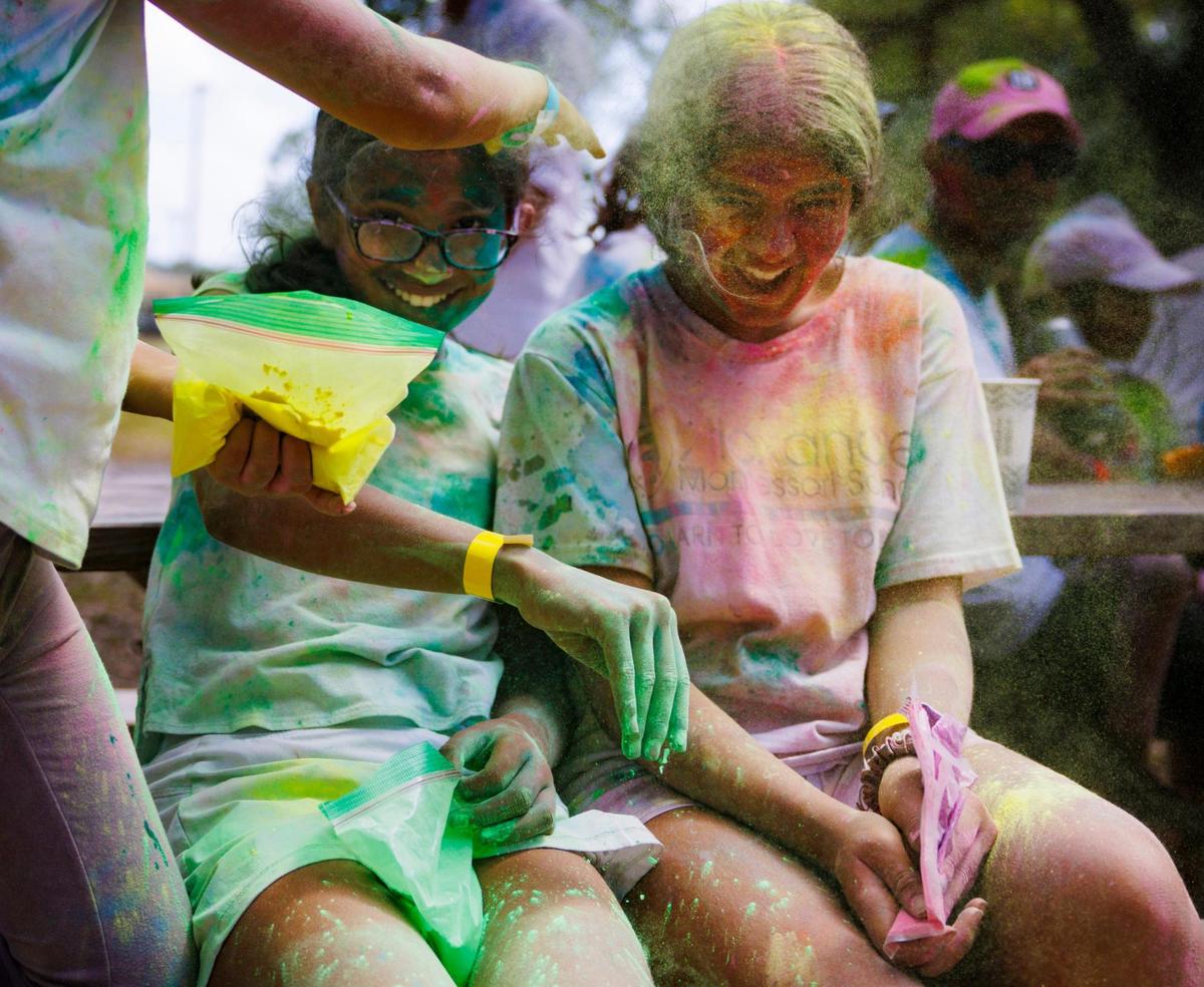 Three girls put yellow and green colored powder on each other during the celebration of Holi, the Hindu festival of colors, on Sunday, March 16, 2025, at Kendall Indian Hammocks Park in Miami, Fla. The colors are a way of showing affection towards each other.