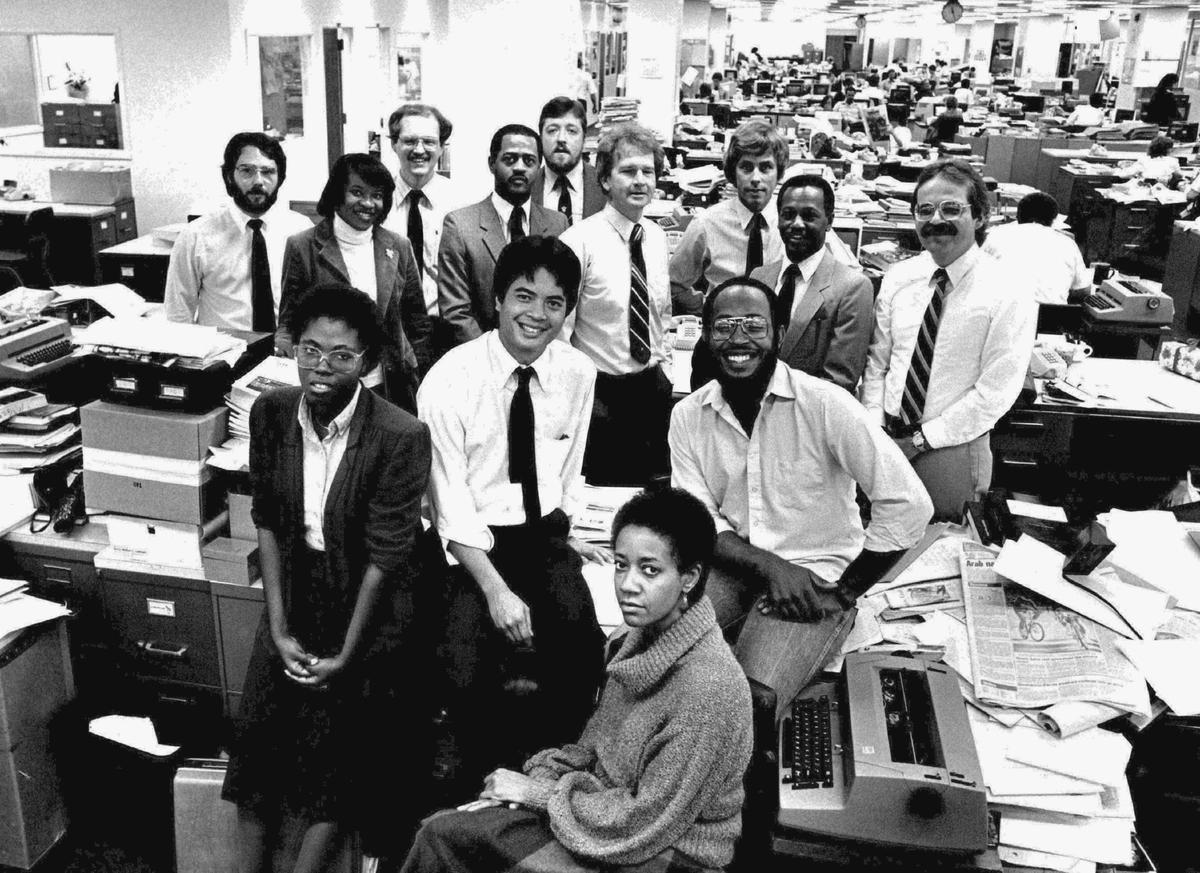 Photo circa December, 1983: Miami Herald Staff Photo -- The Miami Herald’s week-long “Isolation of Black Miami” series concluded Dec. 3, 1983. It was produced by a team of Herald staff writers headed by Bob Lowe. The team included Larry Bivins, Michael Cottman, Itabari Njeri, Carl Hiaasen, Bea Hines, Paul Shannon, Mark Silva, Richard Morin, Ellyn Ferguson and staff photographer Michel du Cille. Graphic design was by Assistant Graphics Editor Claude Cookman. The series was directed by Investigations Editor James Savage. As part of their investigation, Two Herald reporters -- one white and one black -- found apparent racial discrimination at 24 of 45 Dade apartment complexes from North Miami to Coral Gables. In most cases, rental agents told the black reporter that no apartments were available for rent. The white reporter, arriving minutes later, was welcomed to vacant apartments, ready for occupancy. The series won third in the public service category in the Florida Society of Newspaper Editors competition. In this photo in The Herald newsroom at 1 Herald Plaza, Itabari Njeri is seated at the typewriter. Behind her are Ellyn Ferguson, Robert (Bob) Lowe, and Michel du Cille; in the next row, from left, are Bea Hines, Michael Cottman, Jim Savage, Larry Bivins and Richard Morin; last row from left are Mark Silva, David Marcus, Paul Shannon, and Carl Hiaasen.