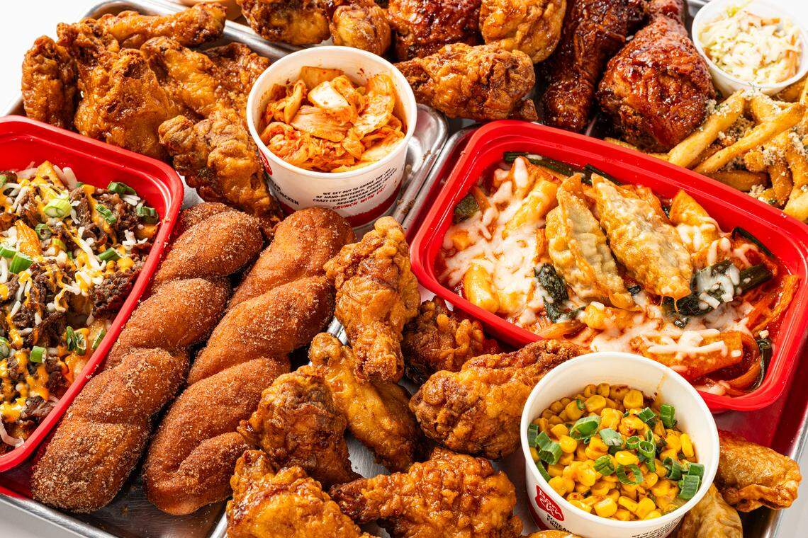 A fried chicken platter at Bonchon, which includes sides like French fries, dumplings and kimchee.