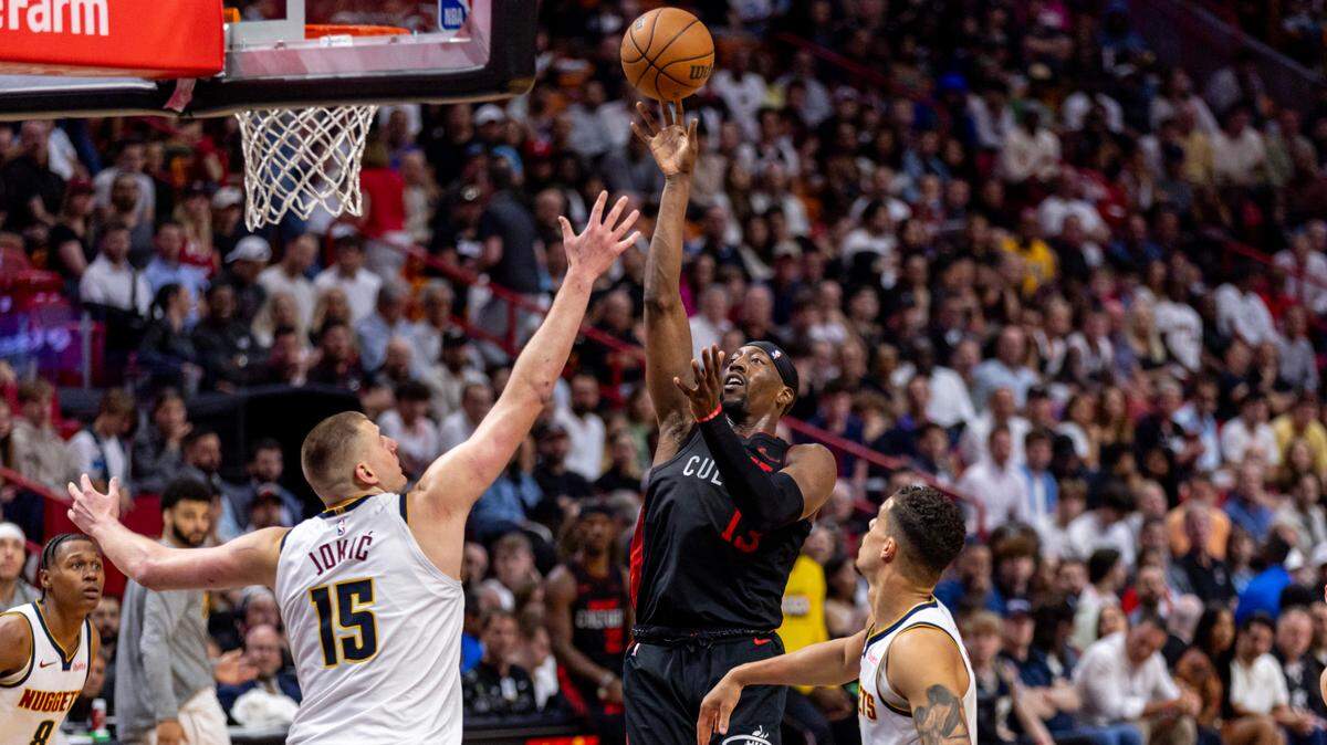El centro del Heat, Bam Adebayo (13), dispara al aro ante la marca de Nikola Jokic (15), de los Nuggets de Denver, en el partido celebrado el 13 de marzo de 2024 en Miami.