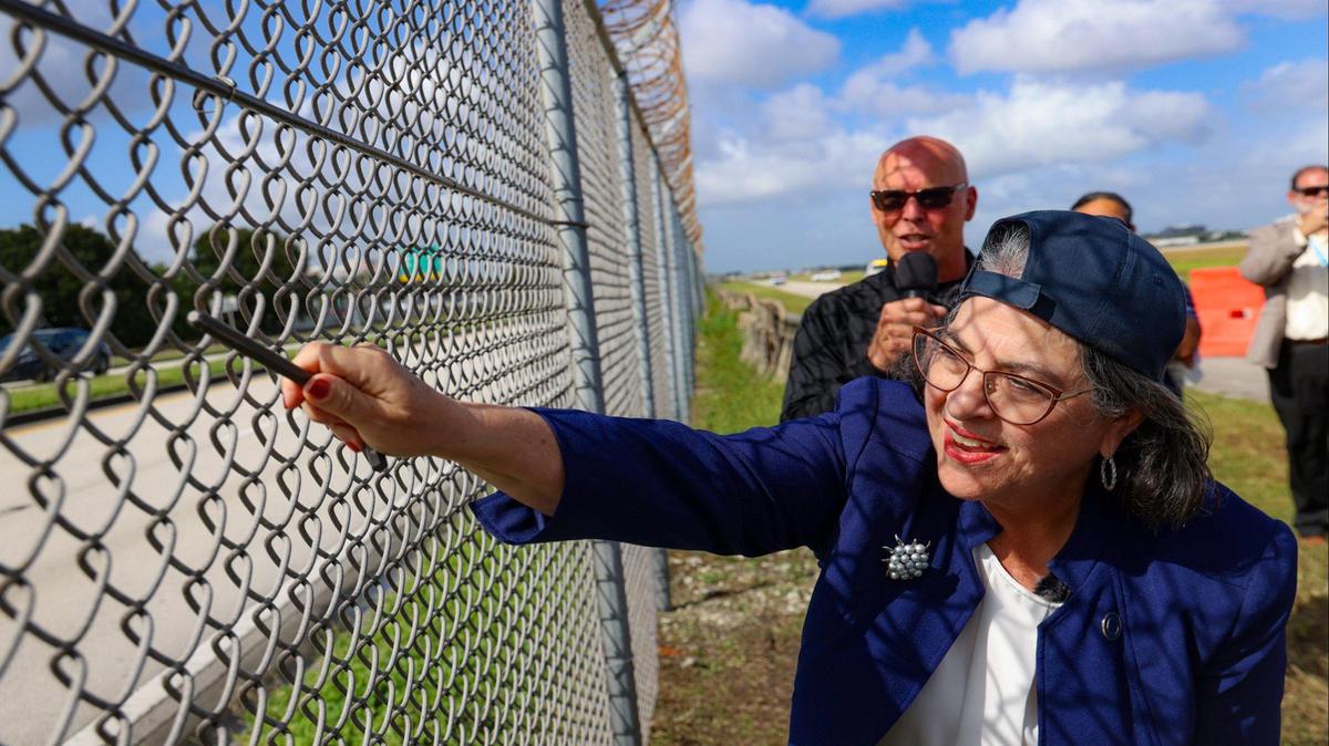 Jim Bamberger of TSA, at left rear, talks through the demonstration of Mayor Daniella Levine Cava as she pretends to cut through the perimeter fence as part of the effectiveness of MIA’s latest intrusion detection system. In partnership with Transportation Security Administration (TSA) officials, MIA gave a live airfield demonstration of Miami International Airport’s new perimeter intrusion detection system on Tuesday, October 22, 2024, in Miami, Florida.