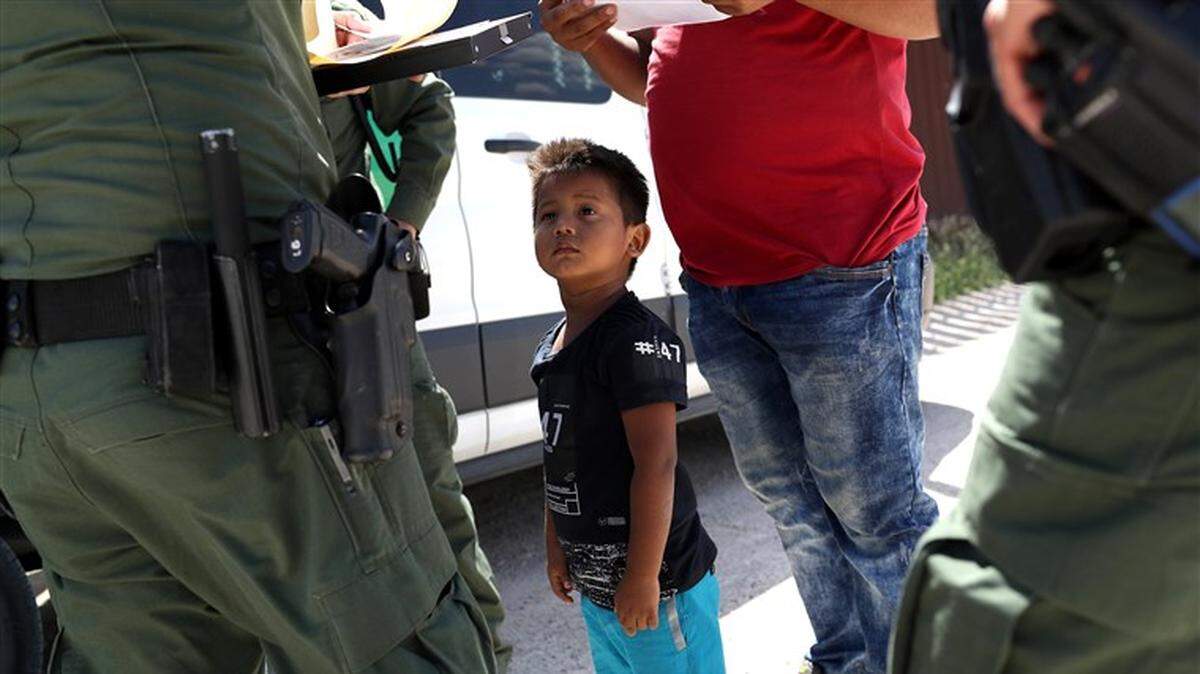 A boy and father from Honduras are taken into custody near Mission, Texas. by U.S. Border Patrol agents. 
