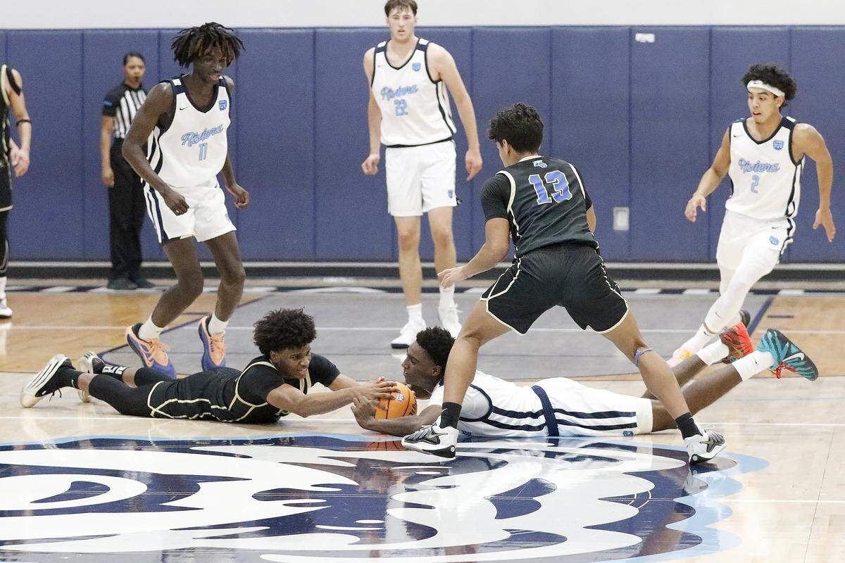 Riviera Prep Bulldogs and Divine Savior Academy Sharks players fight for the ball during the Region 4-2A semifinal boys basketball game on Thursday, February 19, 2026 at Riviera Prep School in Miami. Andrew Uloza / for Miami Herald
