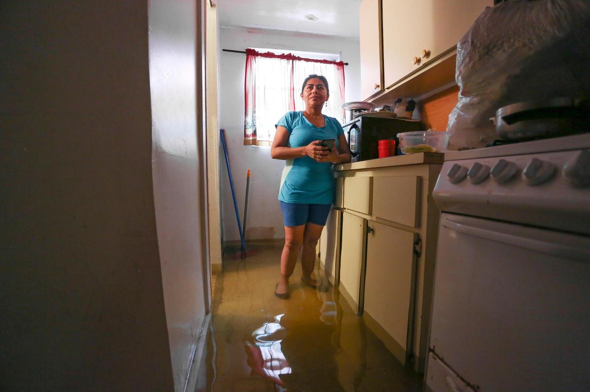Alba Nubia Flores, who lives on Southwest Third Street, stands in the kitchen of her flooded rental home in the neighborhood of Little Havana in Miami, Florida, on Saturday, June 4, 2022.