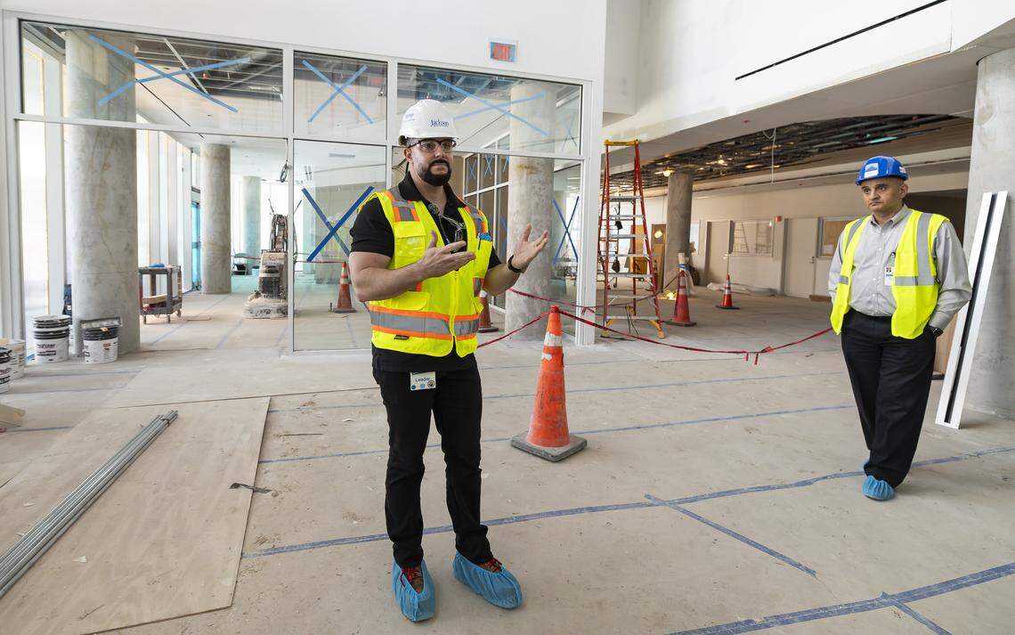 Jackson Memorial Hospital Director of Facilities Design and Construction Jorge Luis Garcia, left, gives a tour of the hospital's new emergency department lobby on Thursday, March 5, 2026, in Miami, Fla. The new facility doubles the size of the current emergency room and is expected to reduce patient wait times.