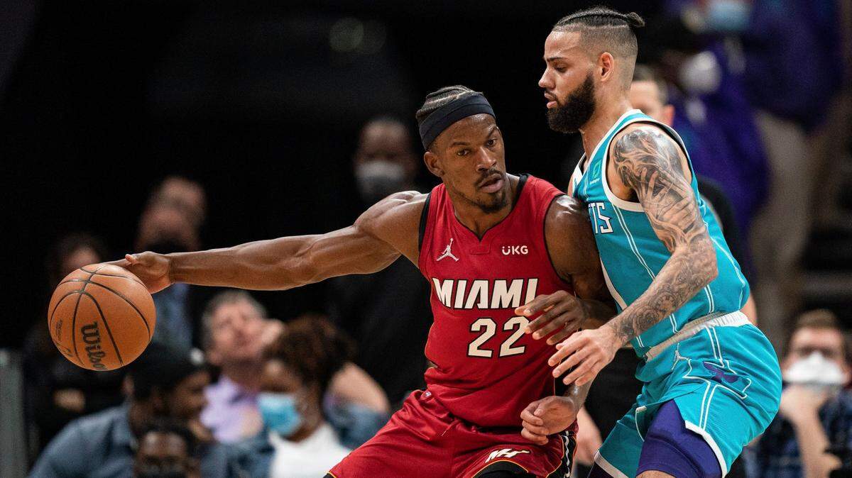 Charlotte Hornets forward Cody Martin (11) guards Miami Heat forward Jimmy Butler (22) during the first half of an NBA basketball game in Charlotte, N.C., Saturday, Feb. 5, 2022.