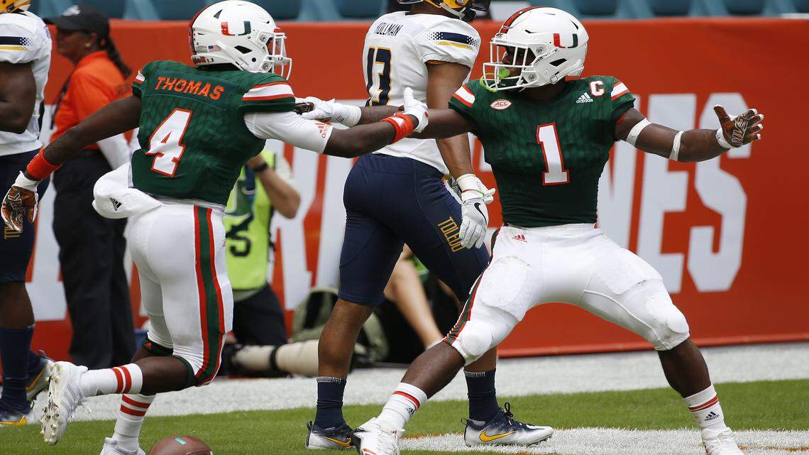 Miami wide receiver Jeff Thomas (4) congratulates running back Mark Walton (1) after Walton ran for a touch down during the first half of an NCAA College football game against Toledo, Saturday, Sept. 23, 2017 in Miami Gardens, Fla.