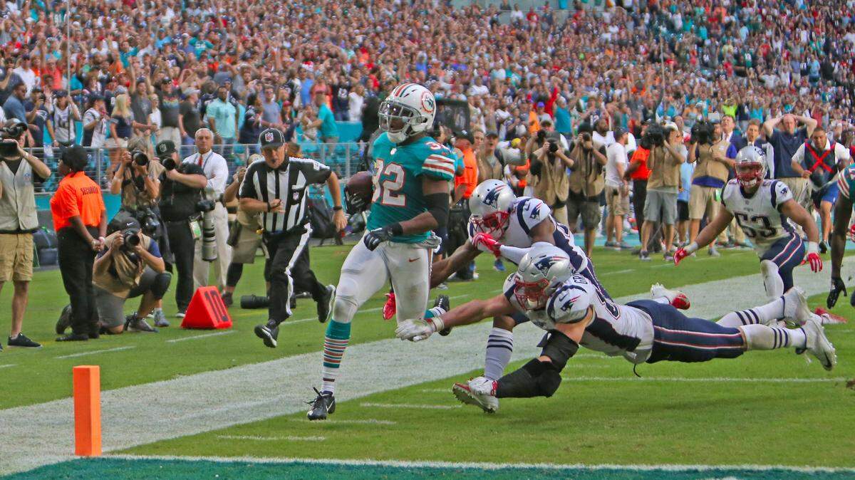 Miami Dolphins running back Kenyan Drake #32 scores the winning touchdown during fourth quarter of an NFL football game against the New England Patriots at Hard Rock Stadium on Sunday, December 9 2018, in Miami Gardens.