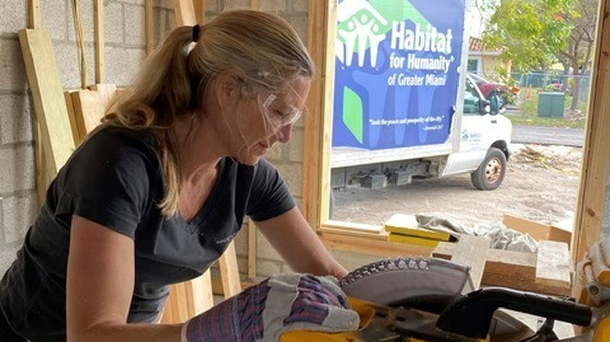 A Habitat For Humanity worker helps build a home.