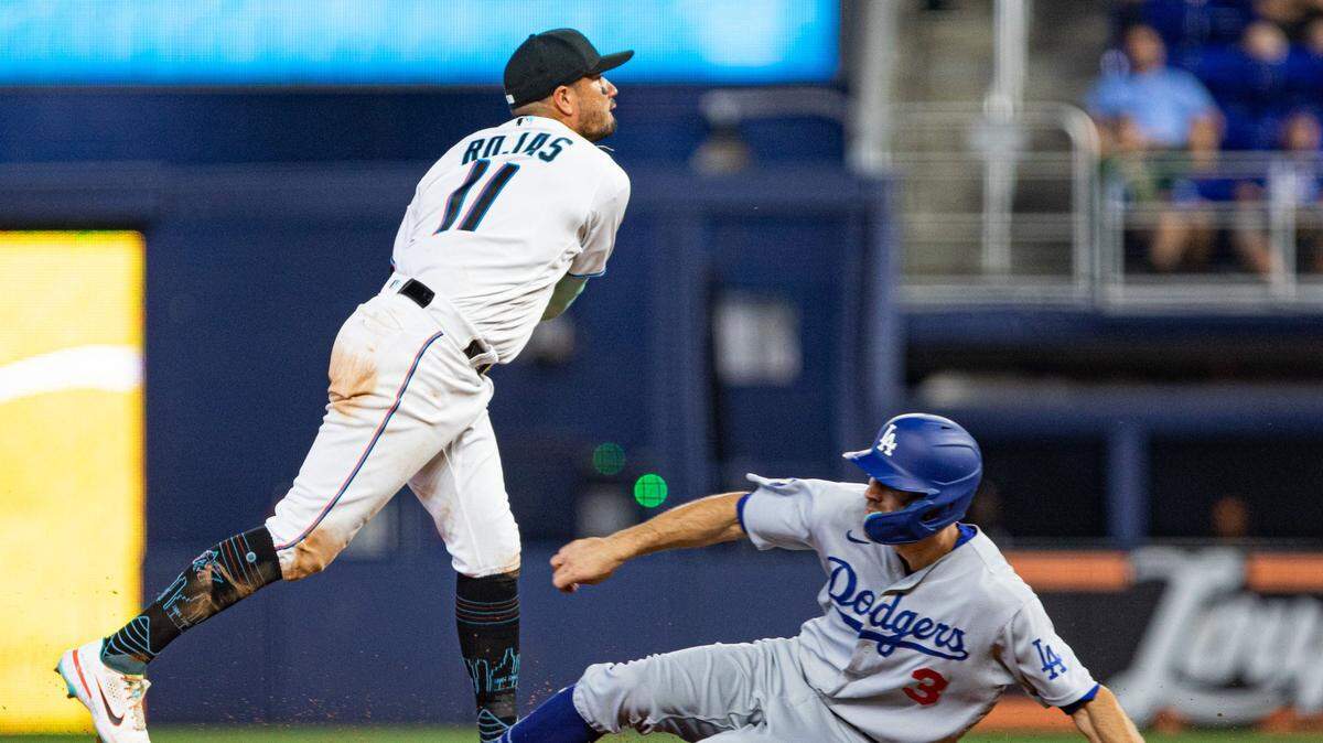 Los Angeles Dodgers left fielder Chris Taylor (3) slides into second base as Miami Marlins shortstop Miguel Rojas (11) throws to first base during the ninth inning of an MLB game at loanDepot park in Miami, Florida, on Sunday, August 28, 2022.
