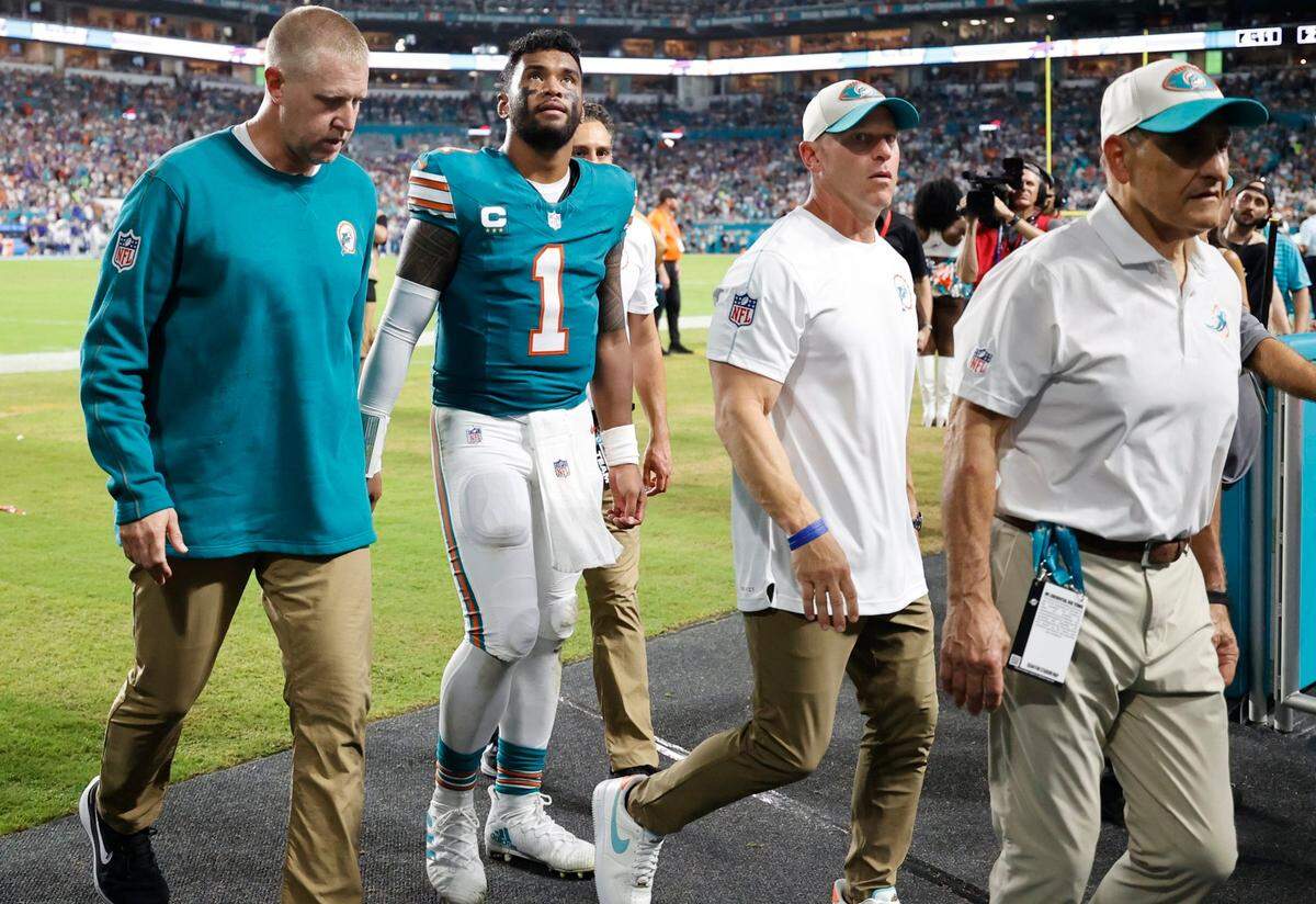 Miami Dolphins quarterback Tua Tagovailoa (1) is assisted off the field in the third quarter after an injury during the game against the Buffalo Bills in an NFL game at Hard Rock Stadium on Thursday, September 12, 2024.