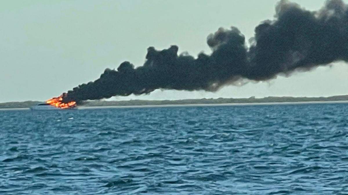 The 100-foot yacht, La Dolce Vita, burns near the Marquesas on March 16, 2021. The Coast Guard is overseeing diesel spill cleanup operations.