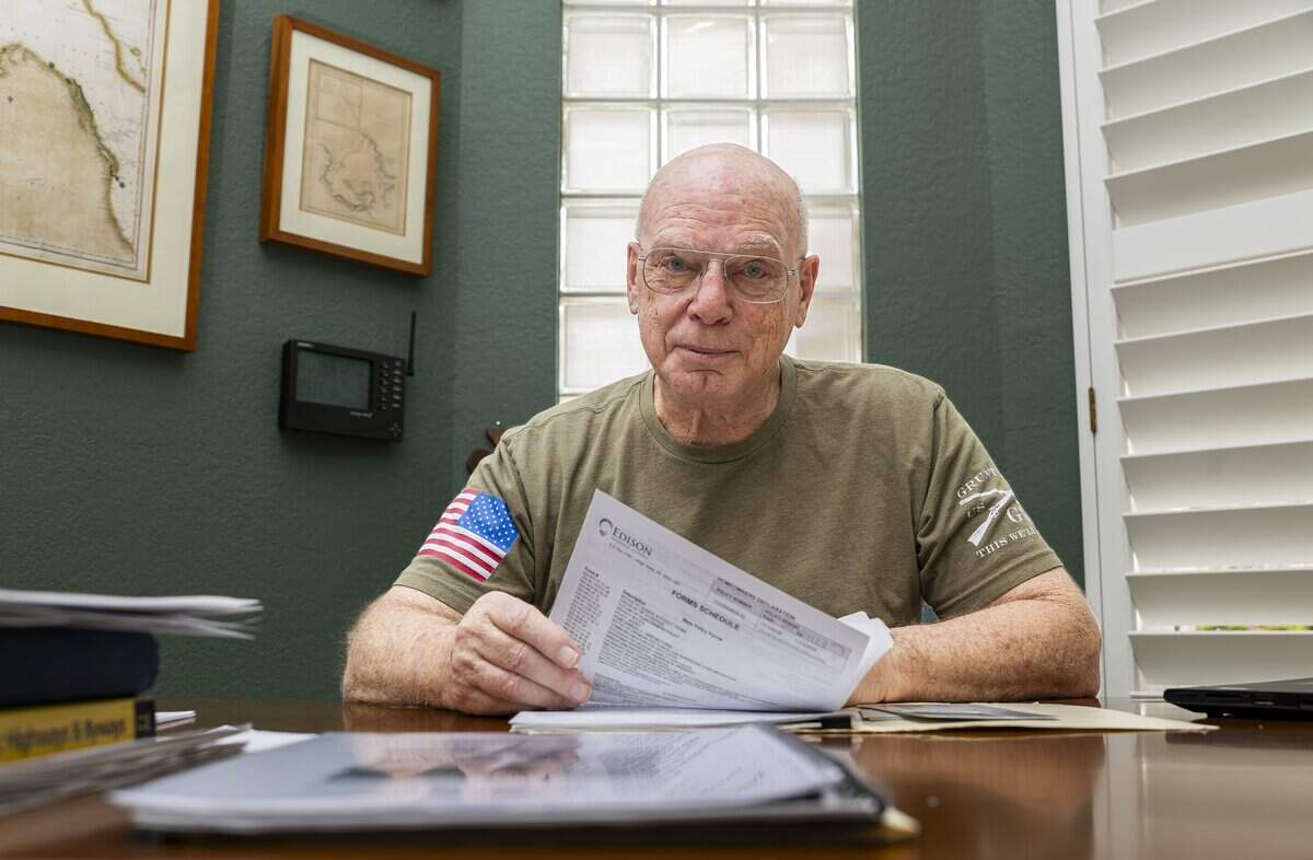 James Weidener looks over his homeowners insurance policy while sitting in his office on Saturday, May 30, 2026, in Coral Springs, Fla. Weidener opted out of homeowners insurance for nine years because of high costs but resumed coverage a couple of years ago.