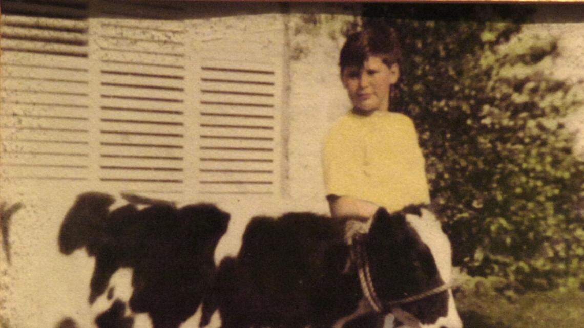 Bob Graham, 13, with “Tiny Two” a 1-year-old dairy cow, in front of his home in Pennsuco.