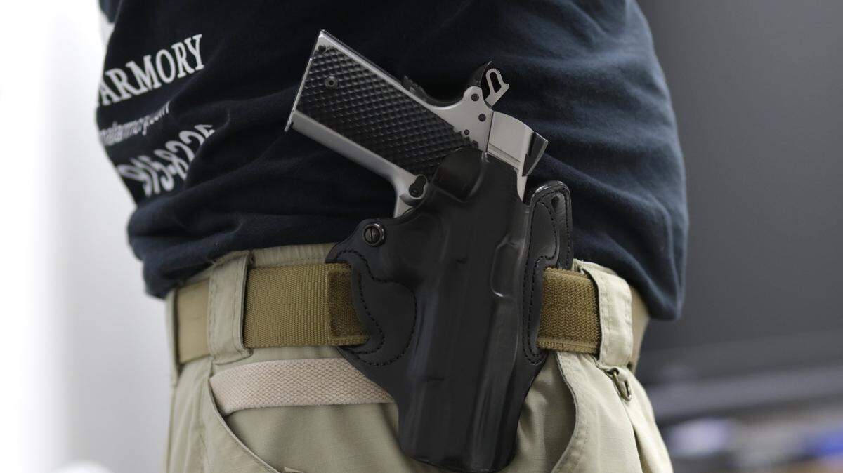In this Jan. 5, 2016 file photo, Mike Weinstein, director of training and security at the National Armory gun store and gun range, wears a Ruger 1911 handgun in a holster as he teaches a concealed weapons permit class in Pompano Beach, Fla.