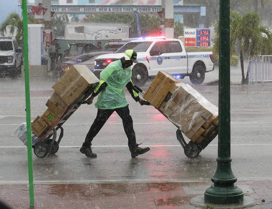 The endless rain makes the vendor's work difficult during Calle Ocho festival on Sunday, March 15, 2026 in Little Havana. Andrew Uloza / for Miami Herald