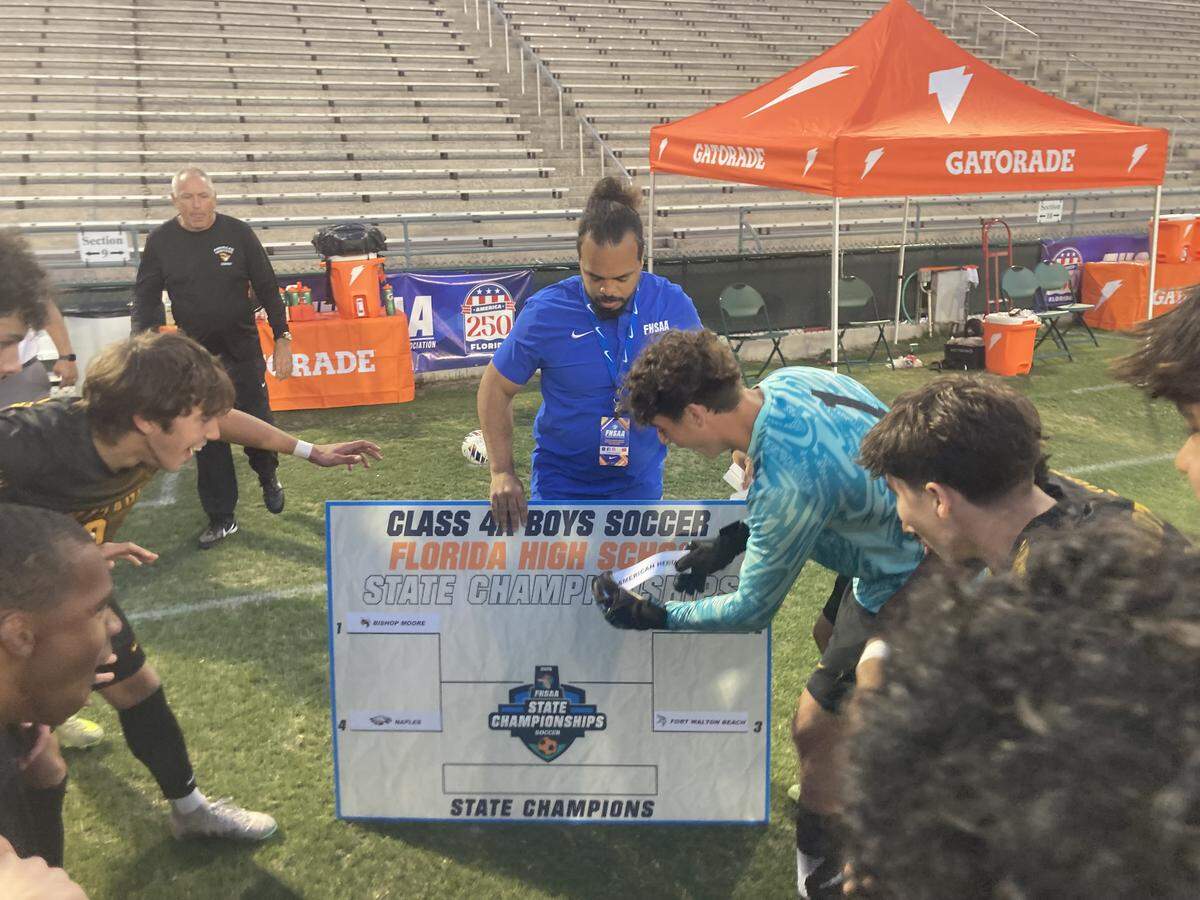 American Heritage goalkeeper Alex Vanhaeren places his school’s name on the championship game line of the Class 4A bracket on Thursday after the Patriots beat Fort Walton Beach in penalty kicks at Spec Martin Stadium in DeLand, Fla.