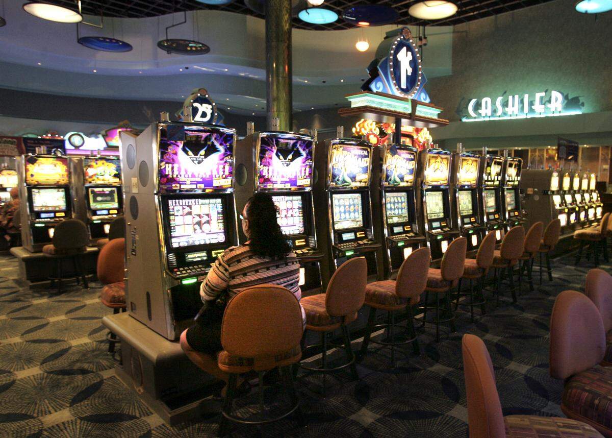 A woman uses a slot machine in the casino at Gulfstream Park. The business opens its 2008 season as a full-fledged racino, with a race track and gambling.