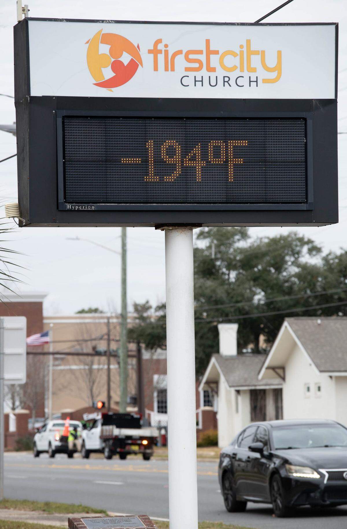 The First City Church sign mistakenly shows a temperature of -194 degrees as crews spreading salt move along Cervantes Street with expected snow approaching the Pensacola area on Tuesday, Jan, 21, 2025.