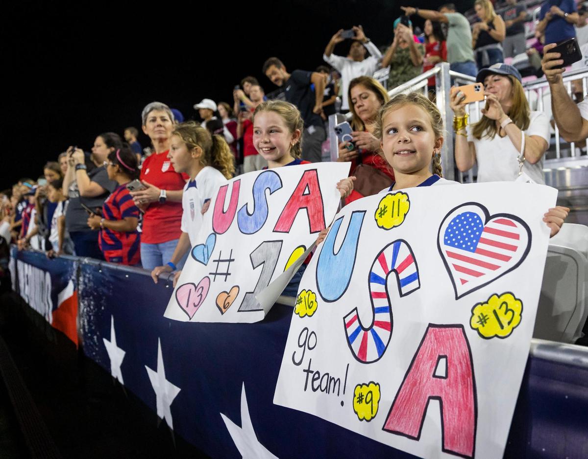 Bibi Castro, 7, right, and her sister, Cati Castro, 9, hold signs before the start of an international friendly soccer match between the United States and Germany at DRV PNK Stadium on Thursday, Nov. 10, 2022, in Fort Lauderdale, Fla.