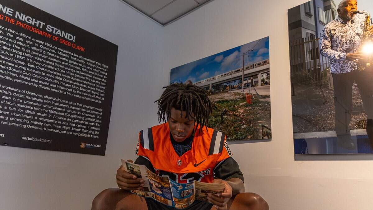 Derrick Johnson Jr., a Booker T. Washington senior high school football player, reads a pamphlet at Hampton Art Lovers art gallery in Overtown, Fla., on Monday, June 15, 2026.