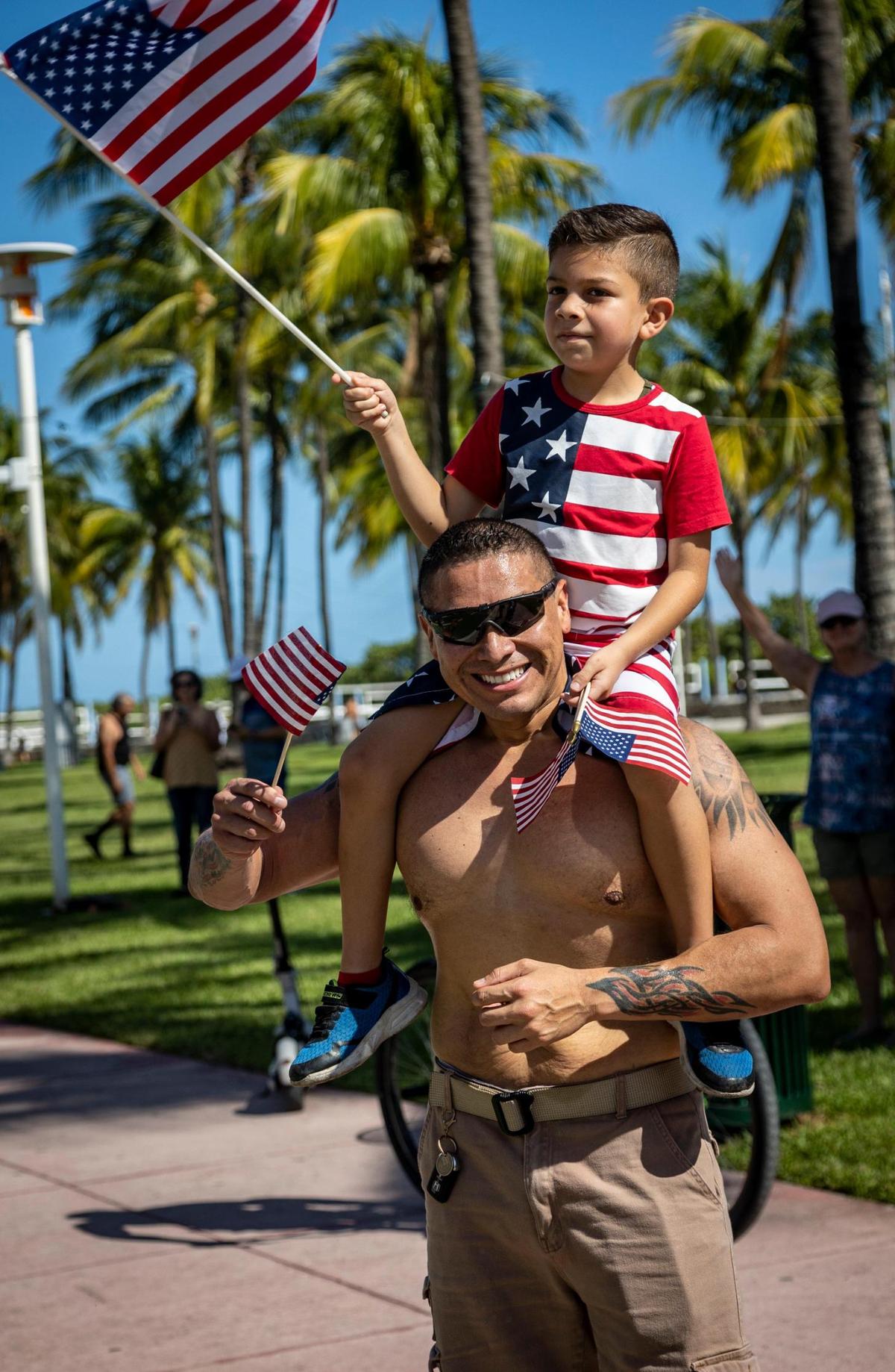 Ever Mulato and his son Shamuel wave American flags as the parade takes off down Ocean Drive in Miami Beach. Miami Beach hosted its 14th Annual Veterans Day parade on Ocean Drive from Fifth to 15th streets.