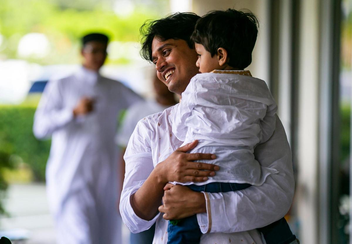 Mohammad Hossain, holds his son, Mohammad Hossain, 1, as they attend the Eid al-Adha prayer ceremony at the Islamic Center of Greater Miami on Saturday, July 9, 2022, in Miami Gardens, Fla.
