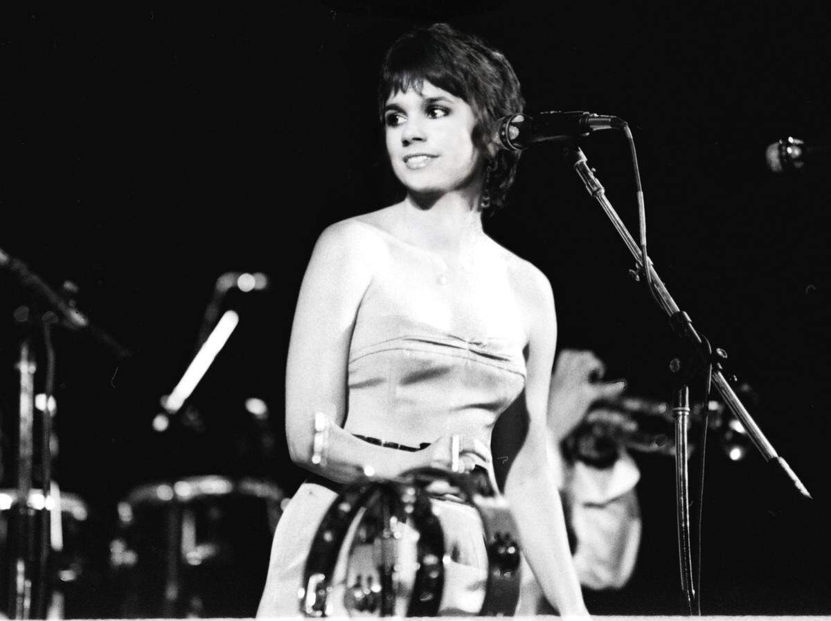 Linda Ronstadt, in concert in 1980, on her Mad Love Tour. The singer recorded a concert from Television Center Studios in Hollywood on April 24, 1980, for an HBO concert. Her band included Danny Kortchmar, Kenny Edwards, Russ Kunkel, Bob Glaub, Billy Payne, Dan Dugmore and backing vocalist Wendy Waldman.