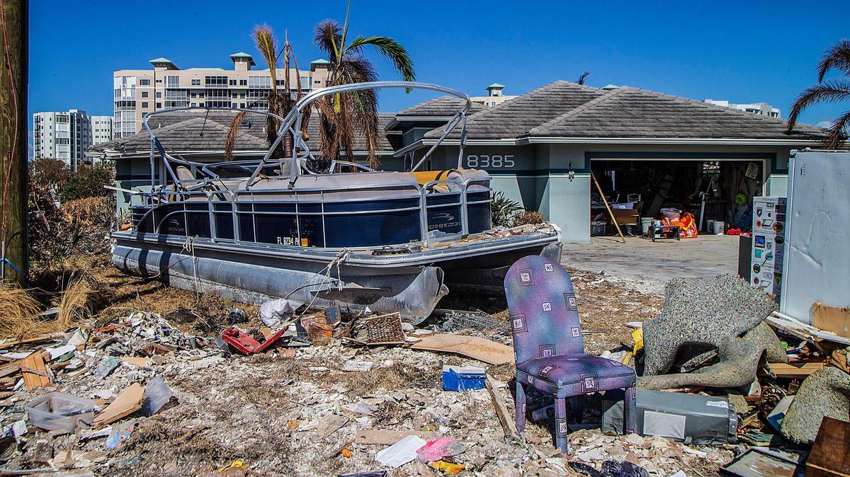 A pontoon boat and damaged household items, including refrigerators and furniture, are set on Lagoon Road in Fort Myers Beach Wednesday, Oct. 27, 2022. The debris is part of the massive cleanup effort underway since Hurricane Ian hit the area as a Category 4 storm Wednesday, Sept. 28, 2022.