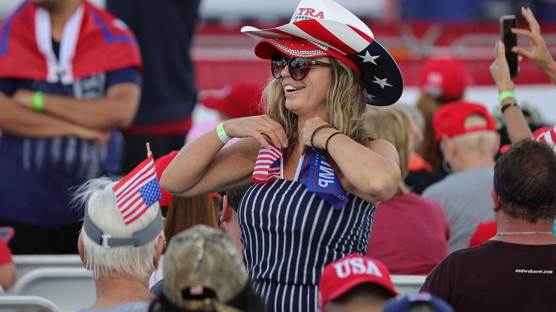 A Trump supporter adjust flags she tucked into her shirt at a rally at the Youth Fairgrounds in Miami. On Sunday, November 6, 2022 former President Donald Trump and a collection of other national and local Republicans campaign with U.S. Sen. Marco Rubio on the eve of the Nov. 8 election.