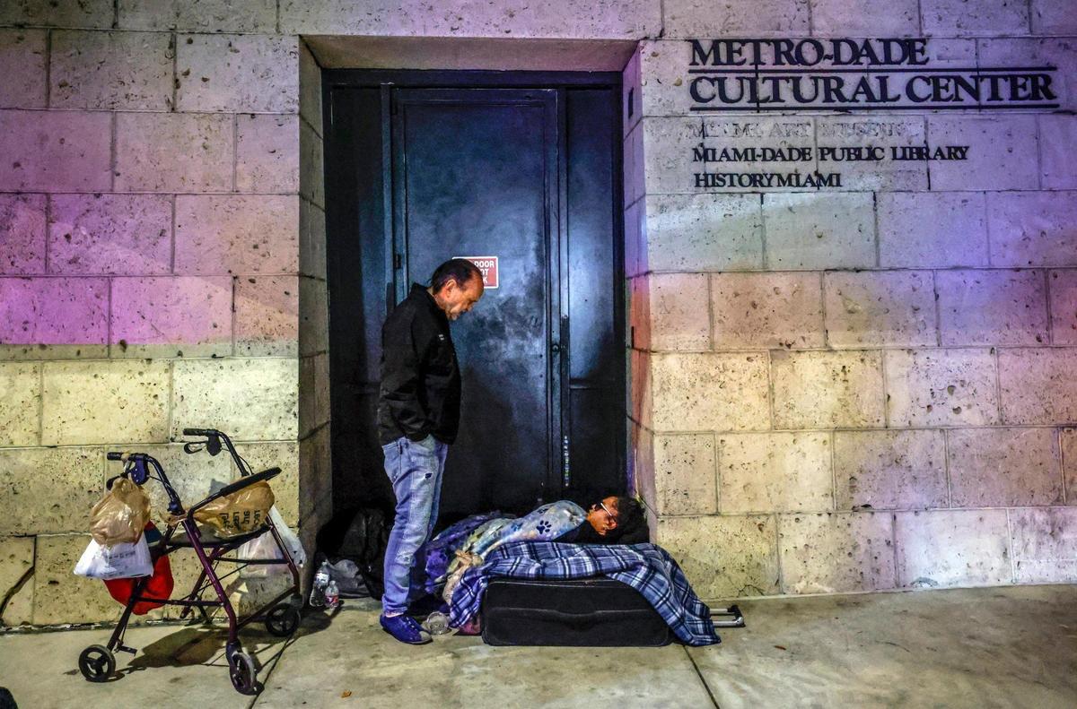 Ron Book, the chair of the Miami-Dade Homeless Trust, speaks to a woman sleeping outside the Metro-Dade Cultural Center during the Homeless Trust’s biannual Homeless Census in Miami on Friday, Jan. 24, 2025.