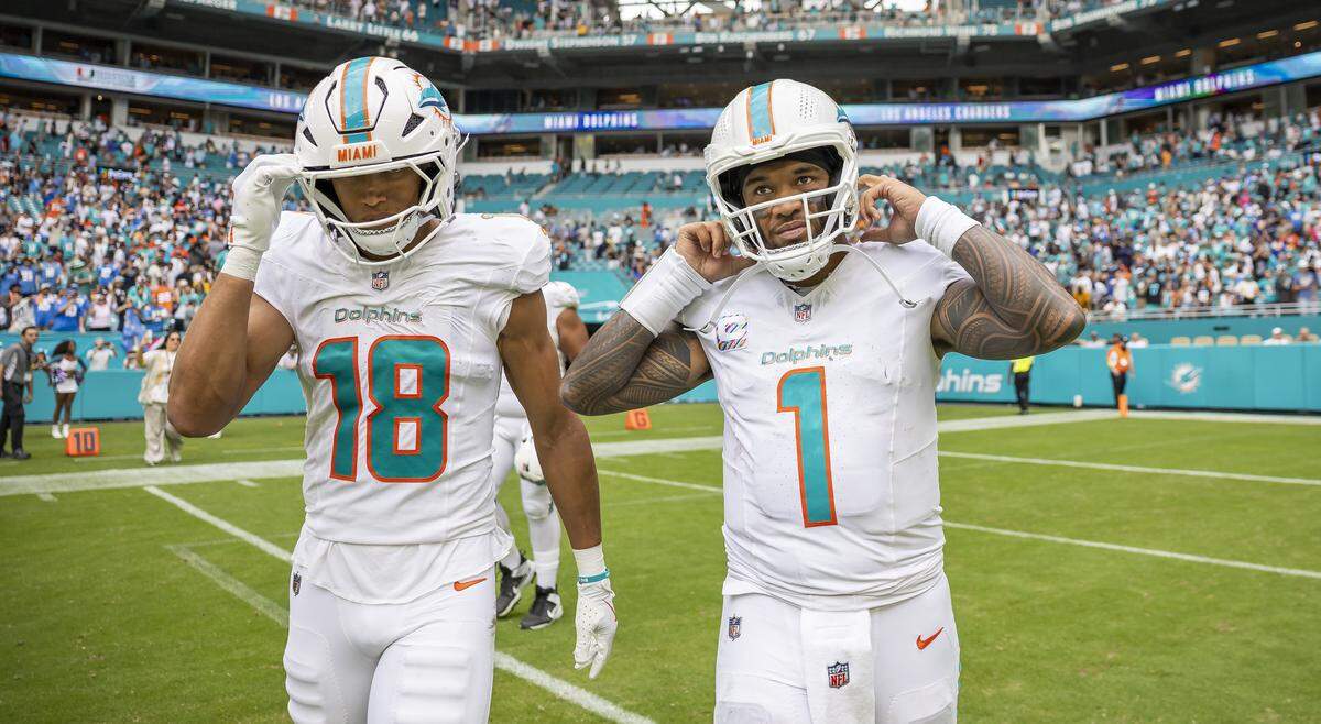 Miami Dolphins quarterback Tua Tagovailoa (1) and wide receiver Nick Westbrook-Ikhine (18) make their way back to the locker room after losing their NFL game against the Los Angeles Chargers at Hard Rock Stadium on Sunday, Oct. 12, 2025, in Miami Gardens, Fla.