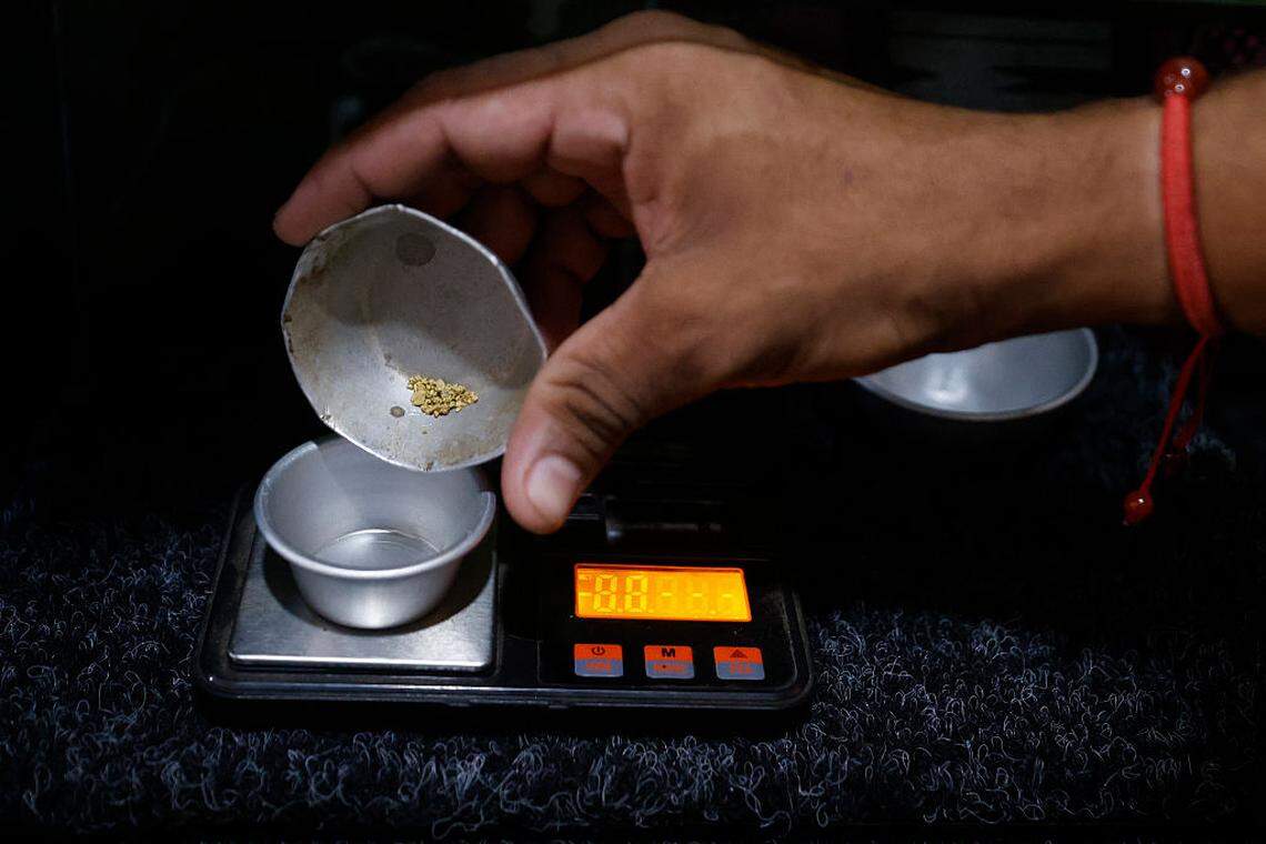 A man pays at a store with grams of gold, which is the main means of payment in the mining town of El Dorado, Bolivar state, Venezuela on May 24, 2025. El Dorado is part of a region christened by the government as the Arco Minero del Orinoco, which has large mineral reserves and is criss-crossed by illegal mining and organized crime, and where trade with gold dust is common currency.       