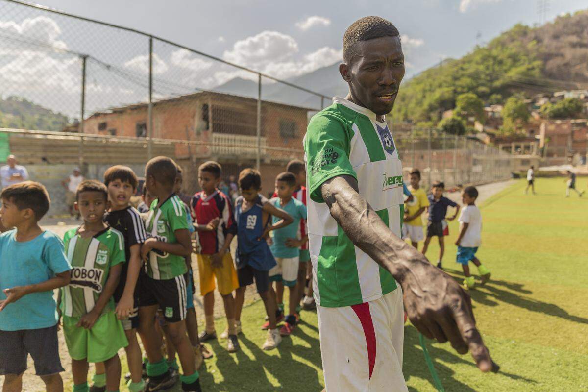Trainer Iván Torres instructs children on how to play soccer in the slum of Petare, Venezuela.  A volunteer coach, he’s driven by his love for soccer and his belief that the discipline of the game helps keep the children from a life of crime and possibly even death in the crime-ridden area near Caracas.
