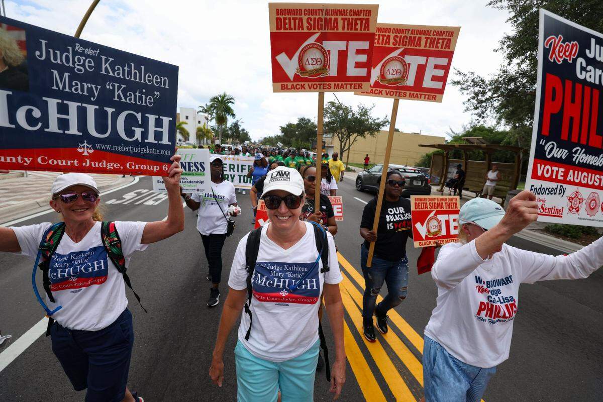 Cherrelyn Seegers, left, and Judge Kathleen “Katie” McHugh, center, and supporters march during the Souls to the Polls march to the African American Research Library and Cultural Center on Sunday, Aug. 18, 2024, in Fort Lauderdale, Fla.