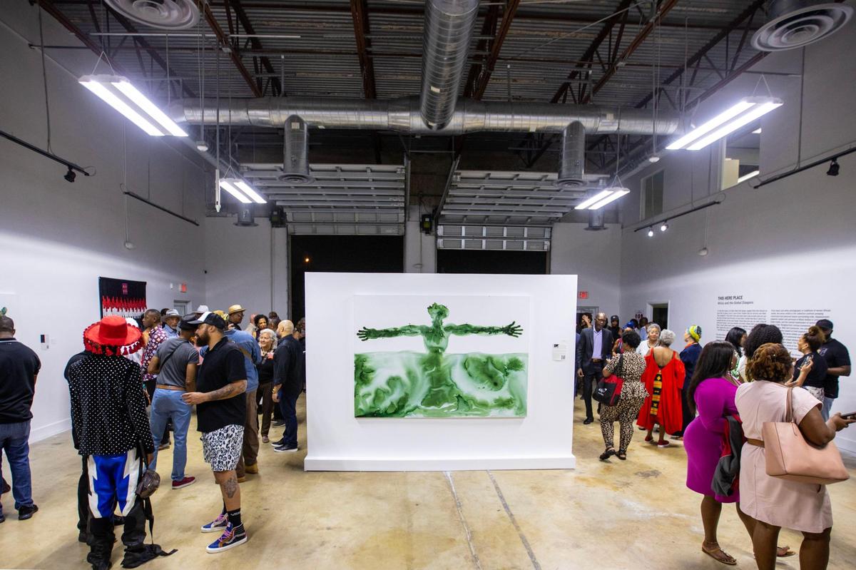 People socialize and view artwork during the Preview for The Art of Transformation event at The ARC and Logan Building in Opa-locka, Florida, on Wednesday, November 30, 2022. The event is a five-day, three-block Mecca of African and Haitian art fair coinciding with Art Basel Miami Beach 2022 and just one of over 40 ‘exhibits’ part of 2022 Art of Black Miami.