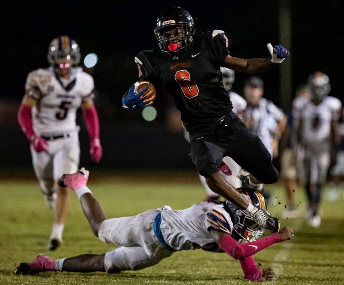 Southridge Spartan wide receiver Jayquan Reid (6) jumps over Homestead Broncos defensive back Sir Robertgeau (27) after catching the ball during the second half of a high school football game at Southridge Park on Friday, Oct. 14, 2022, in Miami, Fla.