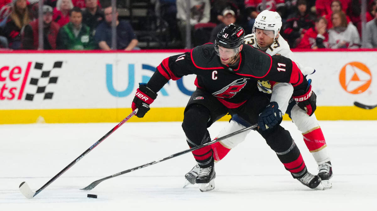 Feb 22, 2024; Raleigh, North Carolina, USA; Carolina Hurricanes center Jordan Staal (11) tries to control the puck against the checking by Florida Panthers center Sam Reinhart (13) during the first period at PNC Arena.
