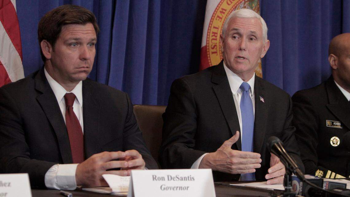 Mike Pence (right) speaks as Florida Governor Ron DeSantis (left) listens during a 2020 press conference at Palm Beach International Airport.