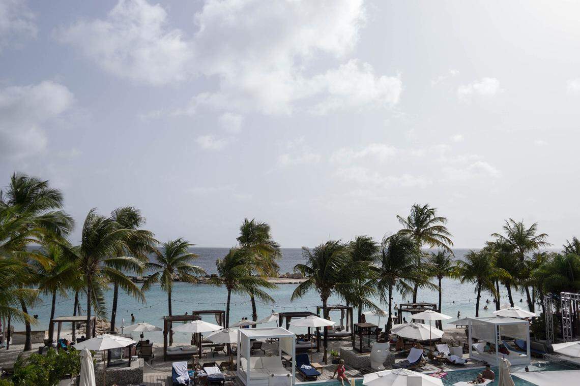 Tourists relax on the beach in Curaçao along the Caribbean Sea. The island and its neighbor Aruba, both governed by the Kingdom of the Netherlands, have become smuggling hubs for Venezuelan ‘blood gold.’