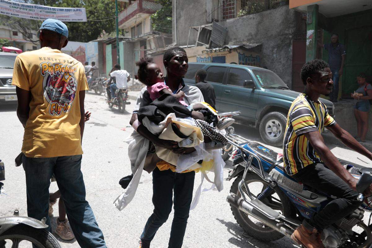 Residents flee their homes to escape clashes between armed gangs in the Carrefour-Feuilles district of Port-au-Prince, Haiti, Tuesday, Aug. 15, 2023.