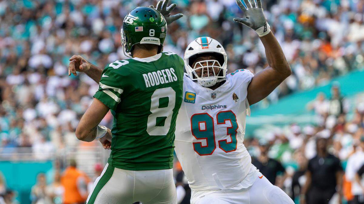 Miami Dolphins defensive tackle Calais Campbell (93) pressures New York Jets quarterback Aaron Rodgers (8) as he throws a pass during the second half of their NFL game at Hard Rock Stadium on Sunday, Dec. 8, 2024, in Miami Gardens, Florida.