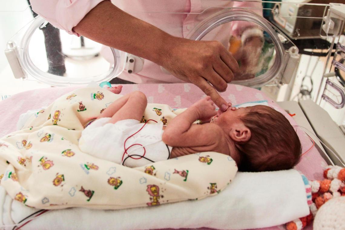 Paul’s finger is held by Alicia, one of his quadruplet daugthers, at Nicklaus Children’s Hospital on July 12.