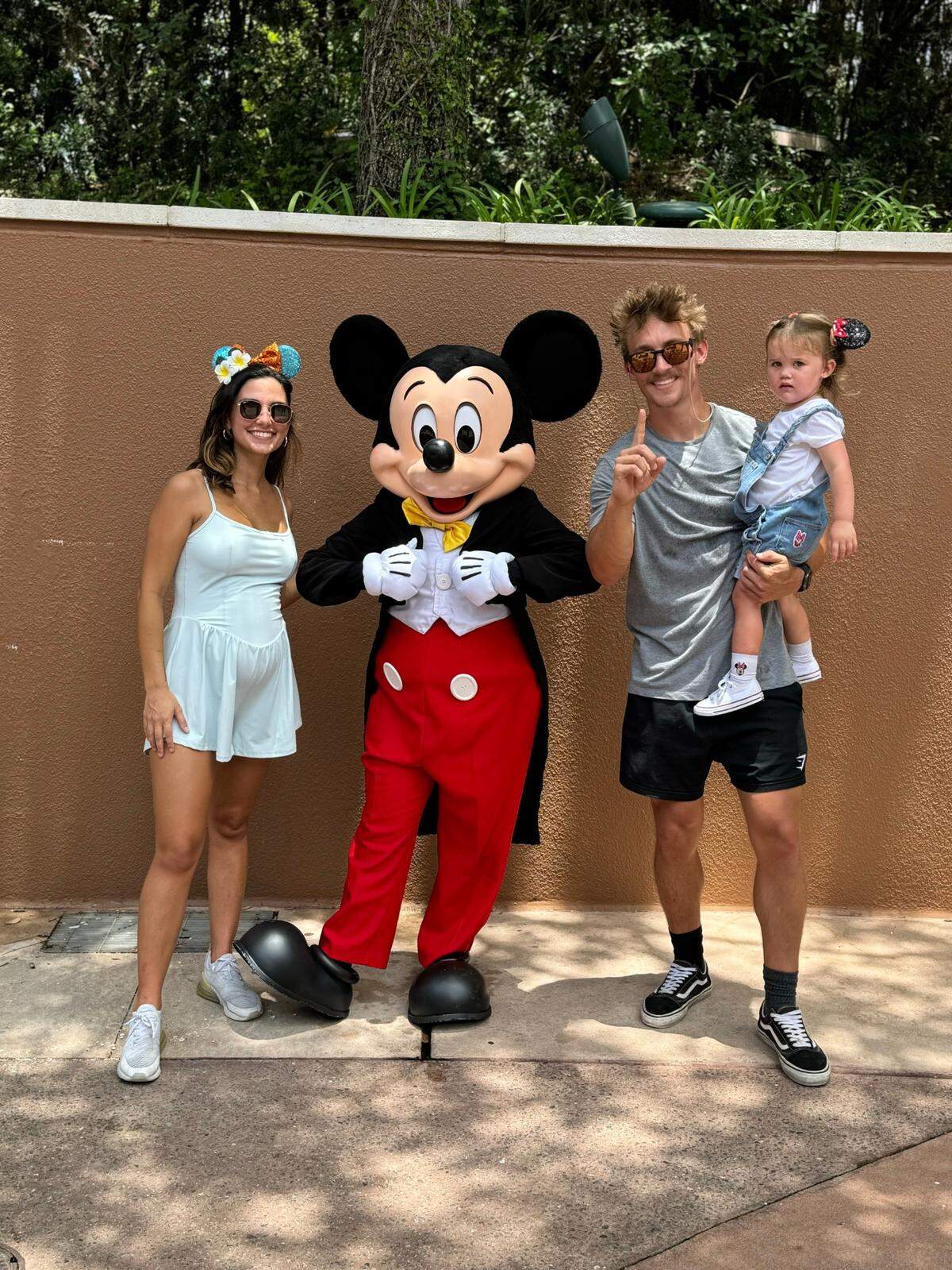 Former FIU punter Stone Wilson (right) holds his daughter, Sterling, alongside his wife Shannon (left) during a trip to Disney World.