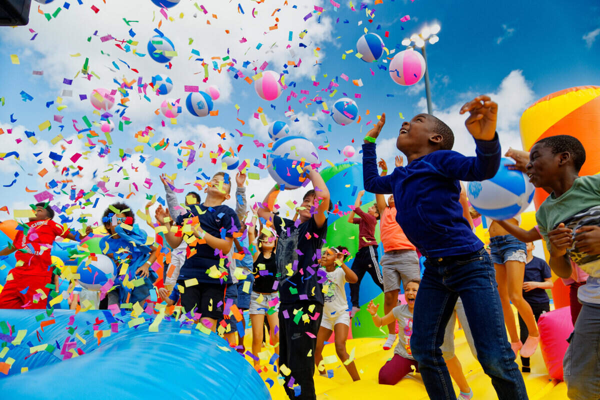 A confetti shower delights kids at The Big Bounce America, the world’s largest bounce house that’s coming to Miami in January.