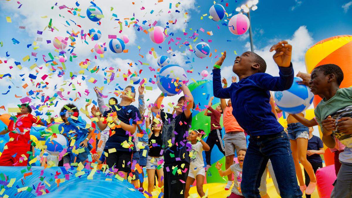 Una lluvia de confeti deleita a los niños en The Big Bounce America, el castillo inflable más grande del mundo, que llegará a Miami en enero.