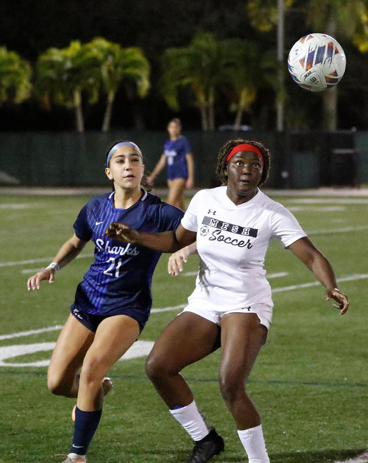 Miami Edison’s Antsy-Love Houanche and NSU University Sharks Giana Ricco (21) fight for the ball during the Region 4-3A girls soccer final on Wednesday at AutoNation Field in Davie.