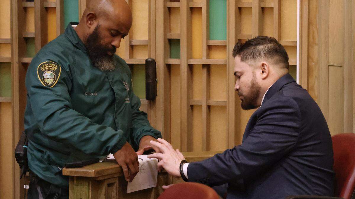 Former Miami-Dade police officer Daniel Ramos-Aviles, right, is fingerprinted after being found guilty Thursday, Sept. 4, 2025, at the Richard E. Gerstein Justice Building in Miami. Ramos-Aviles was convicted of molesting three young girls over a decade in a case overseen by Judge Marisa Tinkler Mendez in Courtroom 4-6.